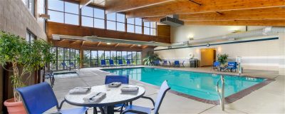 Indoor pool with chairs and tables at Agate Beach Inn